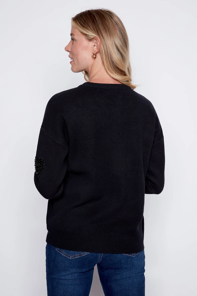 Le pull à motif cœurs animaux et paillettes