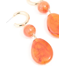 Boucles d’oreilles pendantes ovales en résine orange dorée