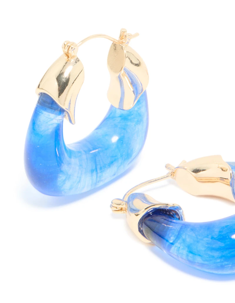 Boucles d’oreilles carrées en résine dorée et bleue.