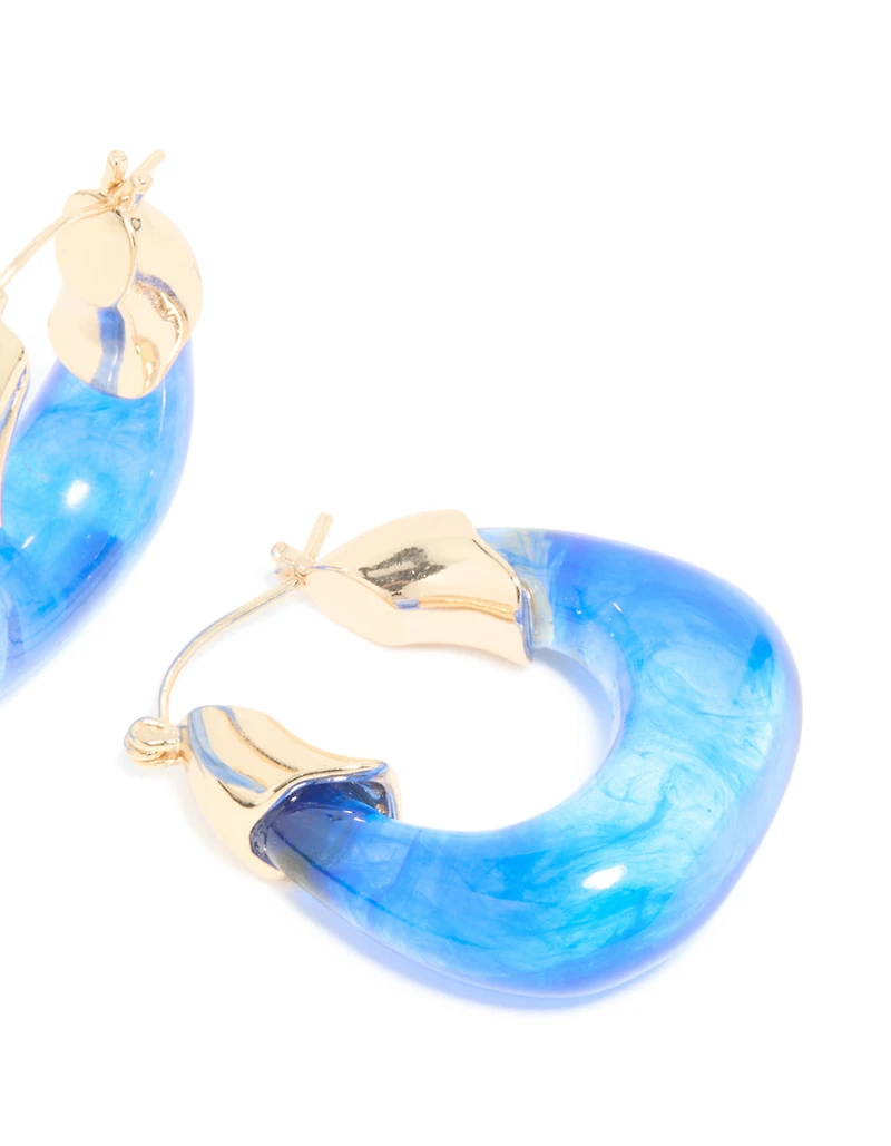 Boucles d’oreilles carrées en résine dorée et bleue.