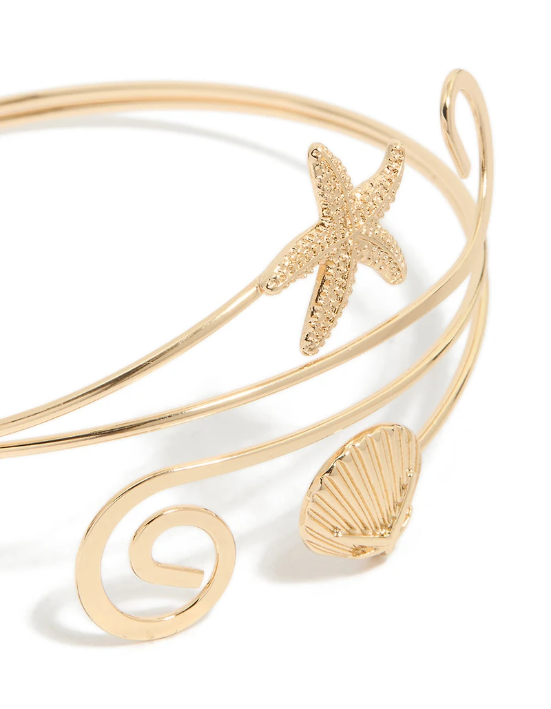Étoile de mer dorée et manchette de bras en coquillage