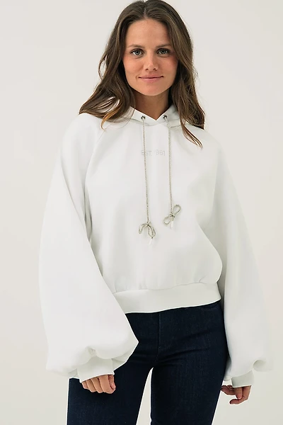 Le chandail à capuche court avec broderie au dos