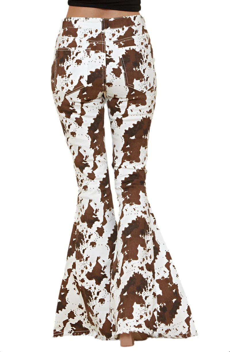 SAINTS  AND HEARTS: COW PRINT FLARED DENIM PANTS