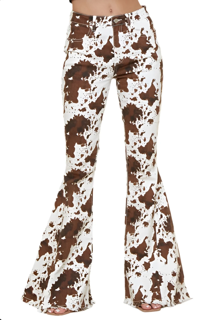 SAINTS  AND HEARTS: COW PRINT FLARED DENIM PANTS