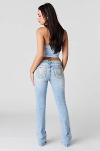 Jean extensible à jambe évasée et taille basse avec poches motif brodé