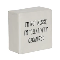 Plaque carrée de table en porcelaine  ”I’m Not Messy, I’m Creatively Organized" Linden de Hometrends