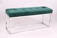 Banc rembourré en velours vert avec base en acier inoxydable.