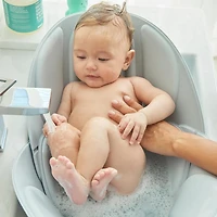 Frida Baby - Soft Sink Baby Bath - Easy To Clean Baby Bathtub + Bath Cushion That Supports Baby's Head - Quick Dry Material - Machine Washable
