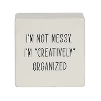 Plaque carrée de table en porcelaine  ”I’m Not Messy, I’m Creatively Organized" Linden de Hometrends