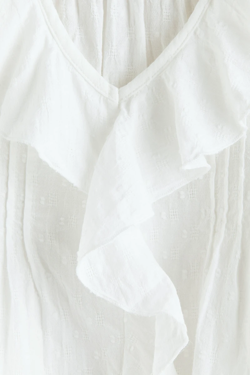 Blouse en plumetis avec bords à volants