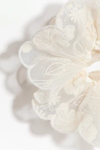 Cache-élastique brodé