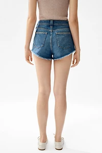 Short frangé en denim