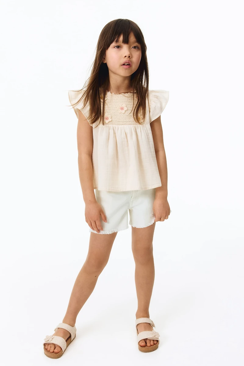 Short frangé en denim