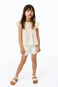 Short frangé en denim