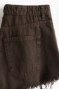 Short en denim à bords frangés