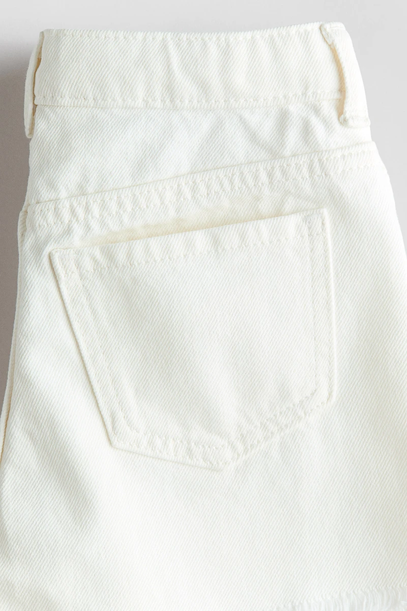 Short frangé en denim