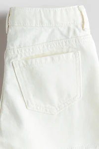 Short frangé en denim
