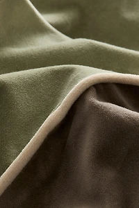 Housse de coussin en velours avec passepoil