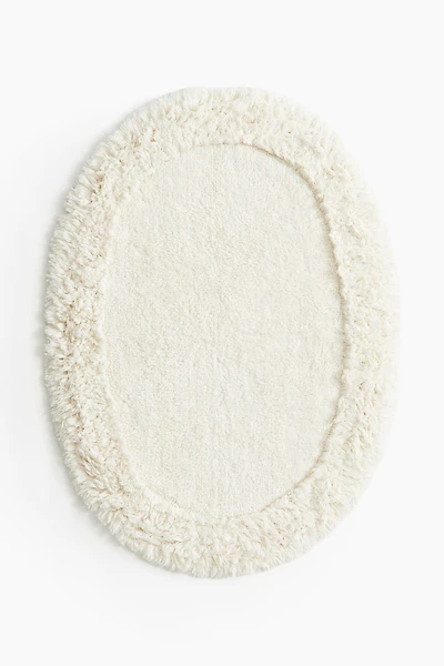 Tapis de bain ovale avec dessus touffeté