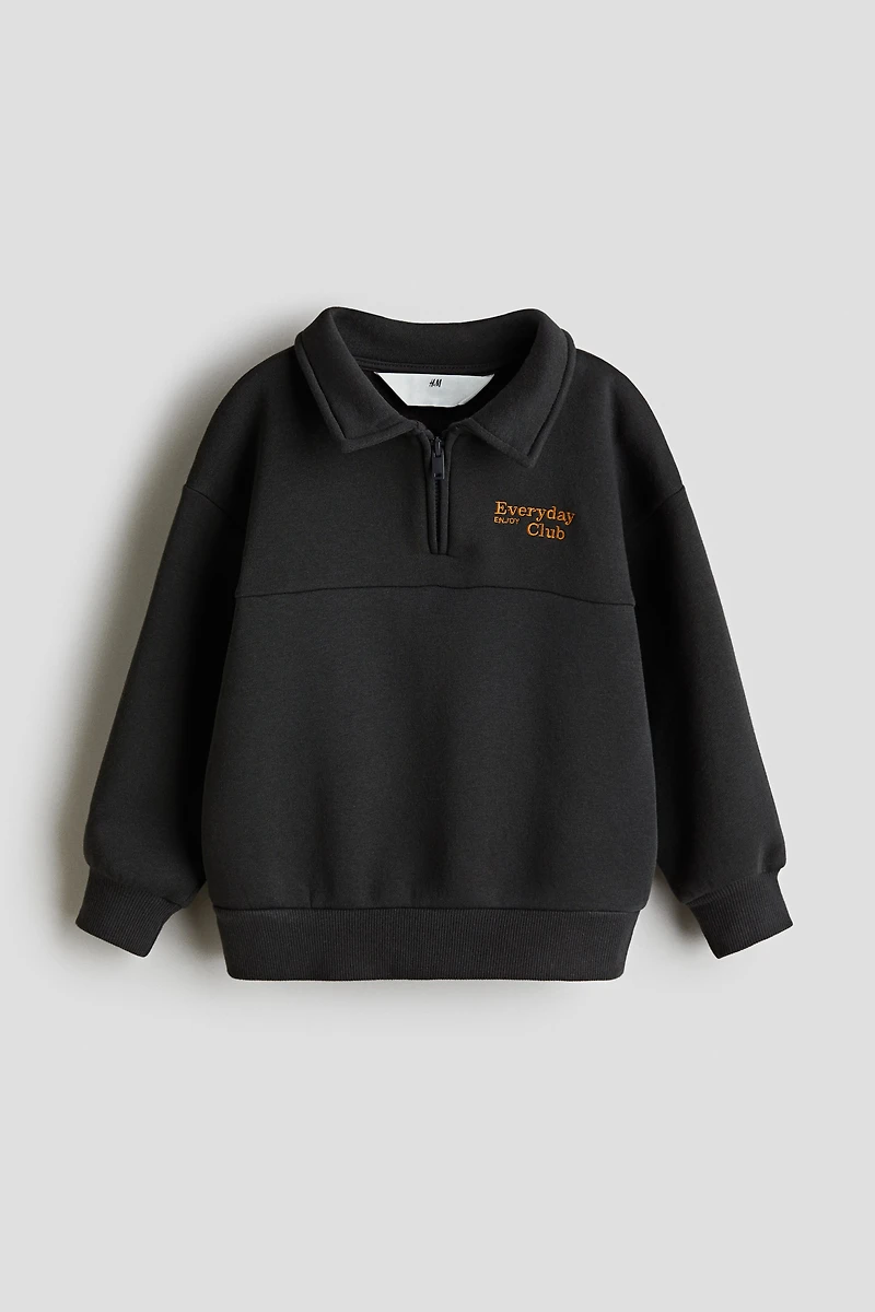 Chandail à col fermeture éclair et détail brodé