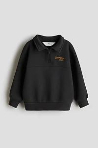 Chandail à col fermeture éclair et détail brodé