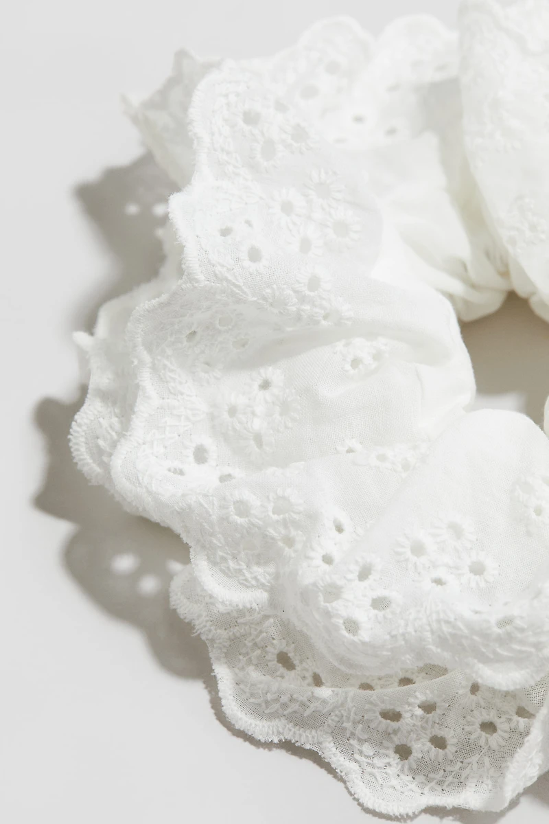 Cache-élastique avec broderie anglaise