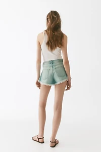 Short frangé en denim