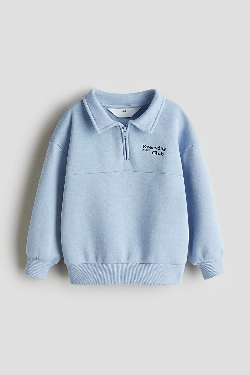 Chandail à col fermeture éclair et détail brodé