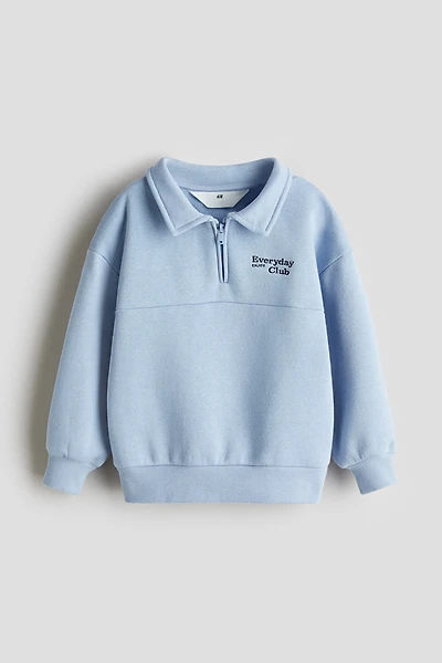 Chandail à col fermeture éclair et détail brodé