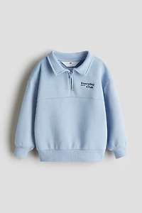 Chandail à col fermeture éclair et détail brodé