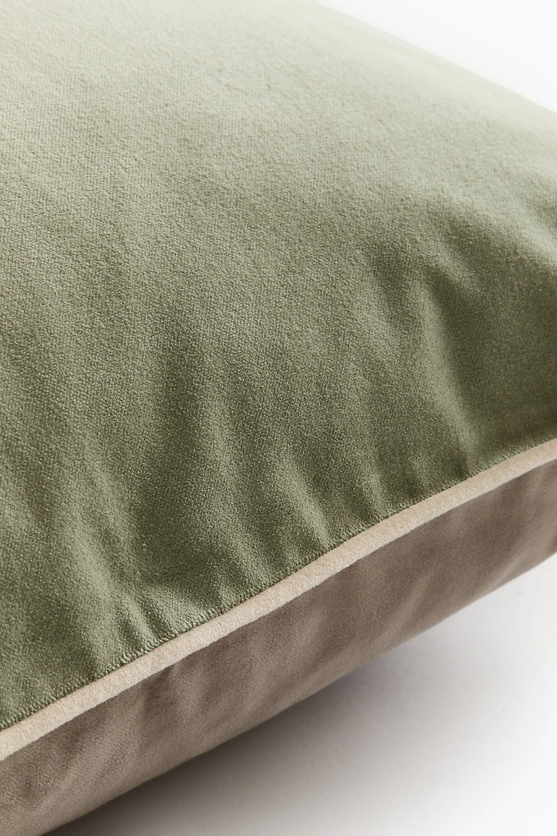 Housse de coussin en velours avec passepoil