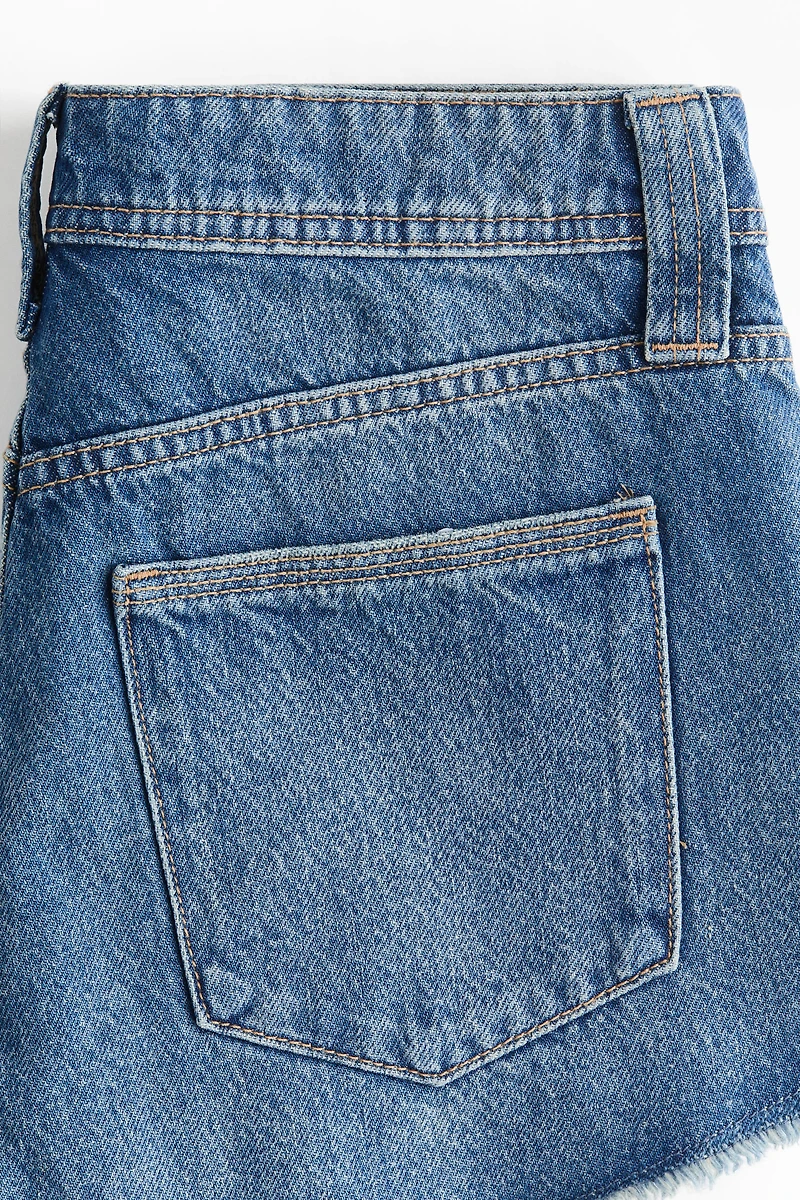 Short frangé en denim