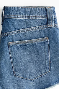Short frangé en denim