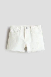 Short frangé en denim