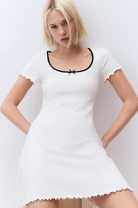 Robe à détails surjetés avec jupe évasée