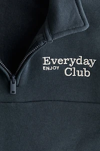 Chandail à col fermeture éclair et détail brodé