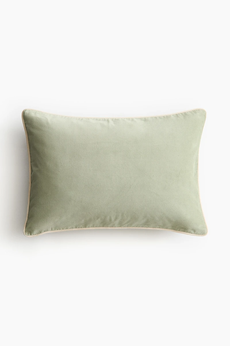 Housse de coussin en velours avec passepoil