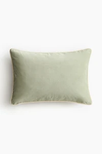 Housse de coussin en velours avec passepoil