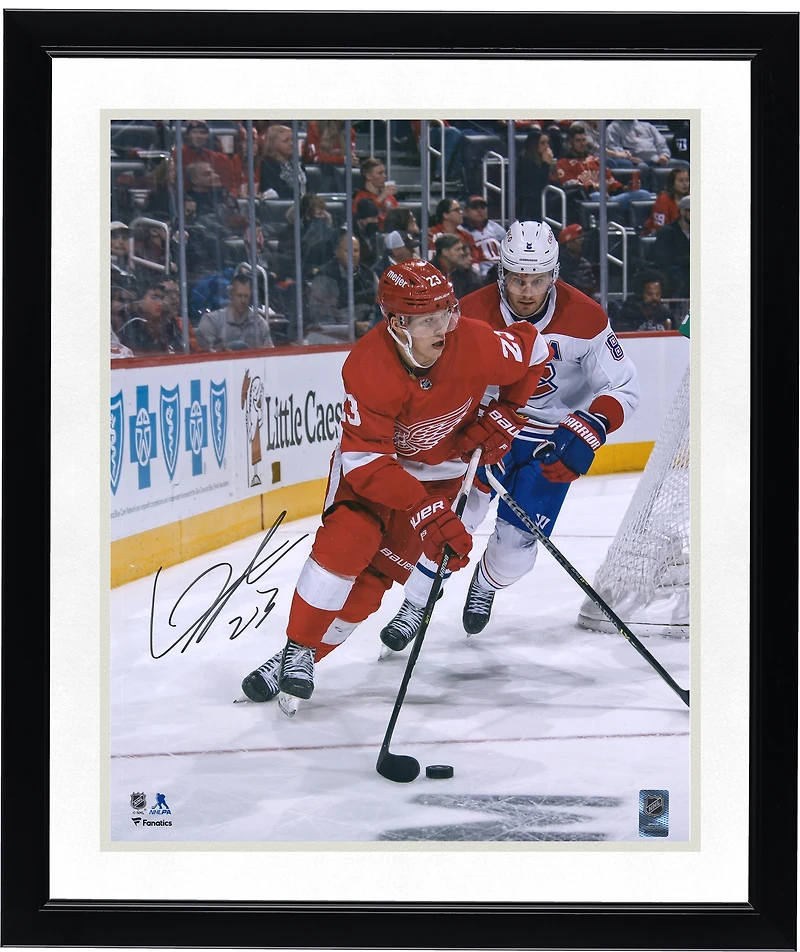 Photo de Lucas Raymond, joueur des Red Wings de Détroit, autographiée (maillot rouge 16" x 20") avec rondelle.
