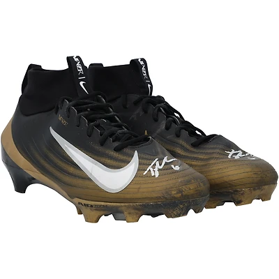 Crampons Nike noirs et or autographiés par Tyler Shough, portés en match par les New Orleans Saints lors de la saison NFL 2025-2026.
