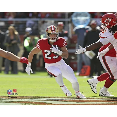 Photo de Christian McCaffrey, joueur non signé des 49ers San Francisco, courant avec le ballon dans son maillot écarlate.