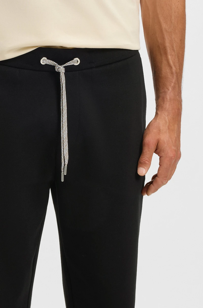 Tracksuit bottoms with patterned drawcord