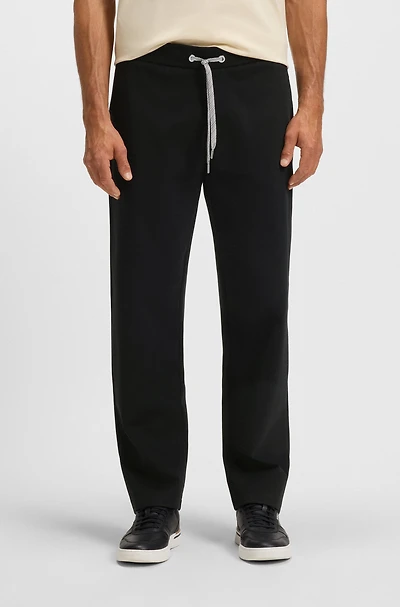 Tracksuit bottoms with patterned drawcord