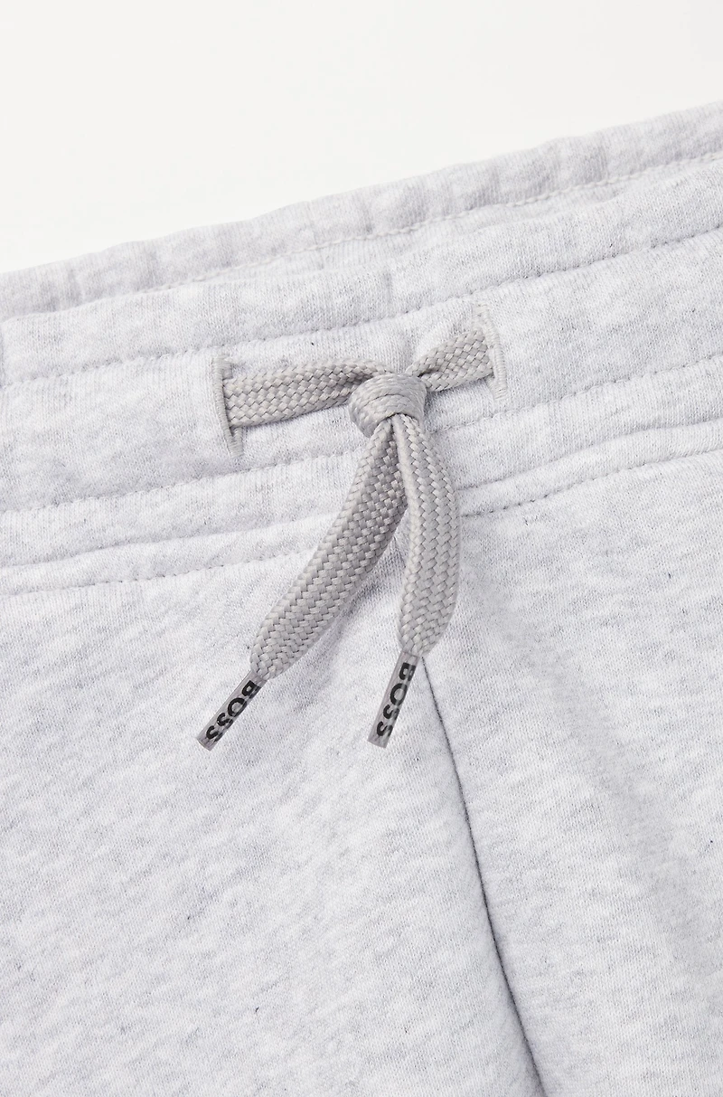 Kids' tracksuit bottoms with vertical logo print