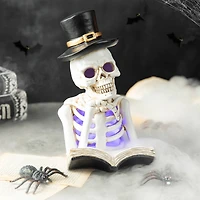 Glitzhome® 10" Lighted Halloween Resin Skull Reading Book Table Décor