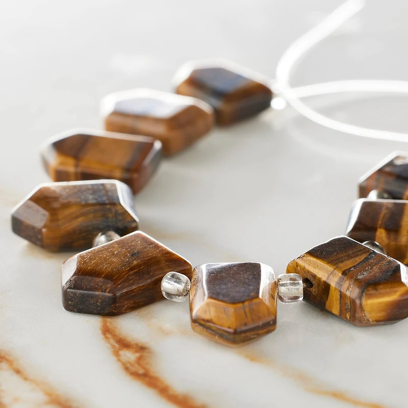 12 Packs: 9 ct. (108 total) Brown Faceted Tiger's Eye Arrow Semi-Precious Beads, 18mm by Bead Landing™