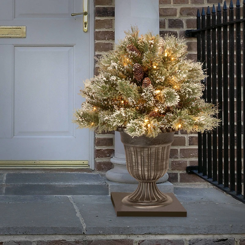 24" Glittery Bristle® Pine Porch Bush in Dark Bronze Plastic Urn with White Tipped Cones