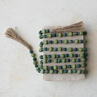 Hello Honey® 12ft. Green & Blue Paulownia Wood Beads with Jute Tassels Garland