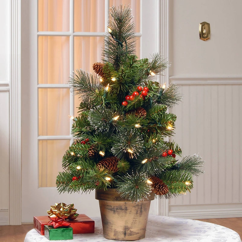2ft. Pre-Lit Crestwood Spruce Small Tree With Silver Bristle, Cones, Red Berries & Glitter In A Plastic Bronze Pot, Clear Lights