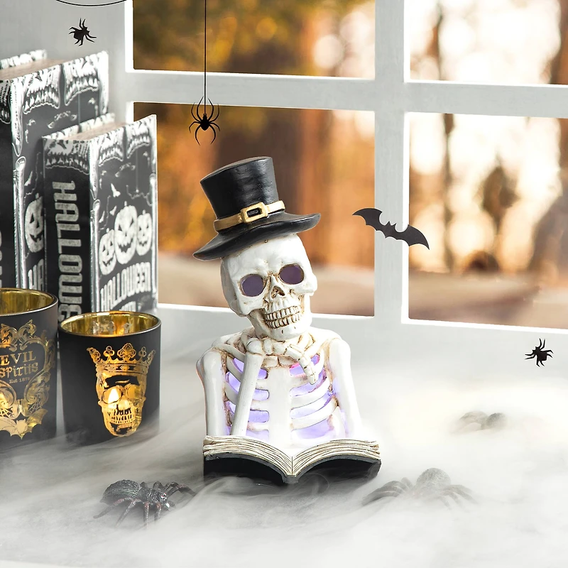 Glitzhome® 10" Lighted Halloween Resin Skull Reading Book Table Décor